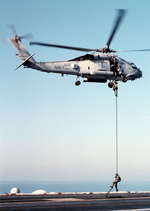 Image: Members of the Explosive Ordnance Disposal team fast rope from a SH-60B Seahawk helicopter.